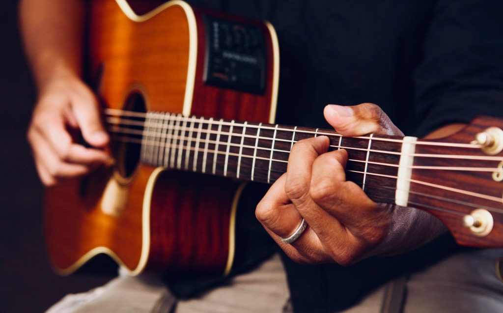 Image of a man playing an acoustic guitar